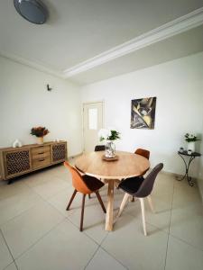 una sala da pranzo con tavolo e sedie in legno di Un Écrin de Sérénité à Dakar Point E a Dakar