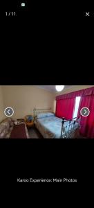 Un dormitorio con una cama y una cortina roja. en karoo experience, en Beaufort West 1 foto más