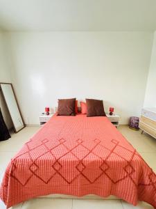 una camera da letto con un letto con un piumone rosso di Un Écrin de Sérénité à Dakar Point E a Dakar