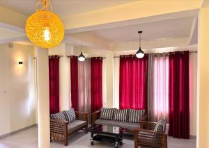 a living room with red curtains and chairs and a table at Tea sprig villa in Boralanda +39 photos