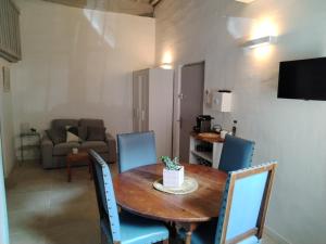 a dining room with a wooden table and blue chairs at Gites Torreillans - Nid douillet - Gite bleu in Torreilles