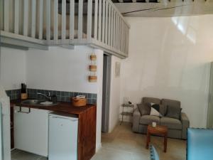 a kitchen and living room with a staircase and a couch at Gites Torreillans - Nid douillet - Gite bleu in Torreilles +7 photos