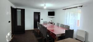 a dining room with a long table and chairs at Casa Veverita in Predeluţ