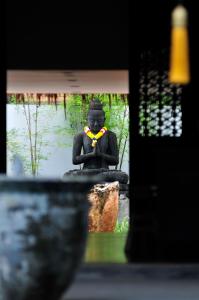 a statue sitting next to a body of water at Villa Samadhi by Samadhi - Adults Only in Kuala Lumpur