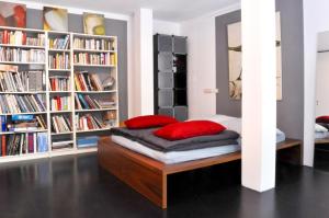 a bed in a room with book shelves at Zwei Zimmer in Atelierwohnung in Cologne