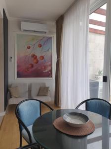 a dining room with a table and chairs and a painting at Apartman Relax Čelebići in Konjic