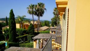 a balcony of a building with trees and palm trees at Chalet Adosado for Rent in Sotogrande in San Roque