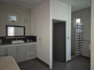 un bagno con lavandino e specchio di Pointe aux Piments Residence a Pointe-aux-Piments