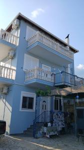 a blue house with white balconies on the side of it at ChristAlex Guesthouse in Himare