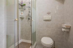 a bathroom with a toilet and a glass shower at La Dimora Etrusca in Capodimonte
