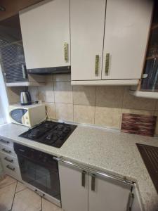 a kitchen with white cabinets and a stove top oven at 2-х комнатная Квартира возле Солнечной галлереи in Yekaterinovka +18 photos