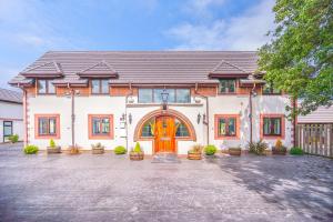 a large white house with a orange door at Farm House Manor Luxury 8 bedrooms & 7 bathrooms Farm House & 40 mins away from Tower in Little Bridgeford