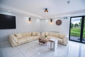 a living room with couches and a tv and a table at Farm House Manor Luxury 8 bedrooms & 7 bathrooms Farm House & 40 mins away from Tower in Little Bridgeford