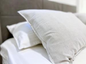 a white pillow sitting on top of a bed at Rab Downtown Place in Rab