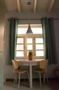 a dining room table with chairs and a window at Porta Di Marina in Chios