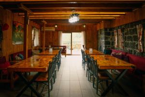 a row of wooden tables in a restaurant with chairs at Elagza Dag Evi in Rize
