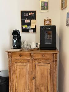 a wooden cabinet with a microwave and a coffee maker on it at Maison Côté Halle "La chambre du Parc" in Saint-Flour