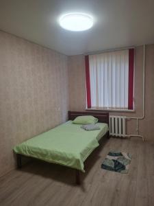 a bedroom with a green bed and a window at 2-х комнатная Квартира возле Солнечной галлереи in Yekaterinovka