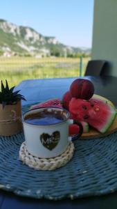 a cup of coffee and a plate of fruit on a table at Home Delic Komarnica in Komarnica