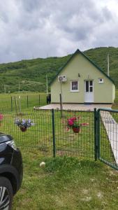 a house with two flower baskets on a fence at Home Delic Komarnica in Komarnica