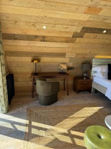 1 dormitorio con techo de madera, cama y escritorio en The Goose In The Woods, en Wellesbourne