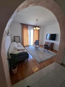 un arco en una sala de estar con sofá y silla en VILLA Apartments Mate Cebalo, en Lumbarda