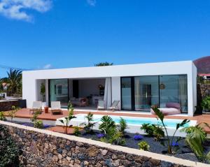 a modern villa with a swimming pool and a house at Villa Lima by Aura Collection in La Oliva