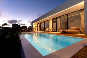a swimming pool in front of a house at Villa Lima by Aura Collection in La Oliva