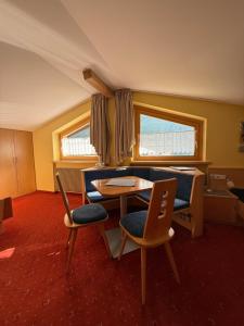 a living room with a table and chairs at Garni Appartements Des Alpes in Solda