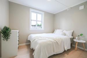 a white bedroom with a bed and a window at Cozy apartment - Walking distance to Kristiansand city center in Kristiansand