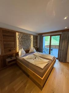 a large bed in a room with a large window at Garni Appartements Des Alpes in Solda