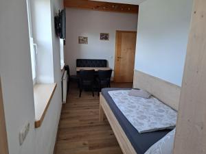 a small room with a bed and a dining room at Villa-Musica in Fieberbrunn