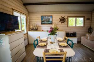 a kitchen and dining room with a table and chairs at Le Chalet Cavronnais in Cavron-Saint-Martin