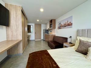 a bedroom with a bed and a living room at Apartaestudio con balcón en zona top in Armenia