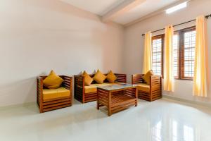 a living room with chairs and a table at Hotel O Home Elegant Stay Fine Nest Homes in Wayanad +45 photos