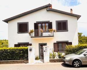 a white house with flowers on the balconies at Paloma nel bosco in Sutri