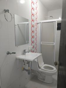 a bathroom with a toilet and a sink and a mirror at Casa Lina in Montería