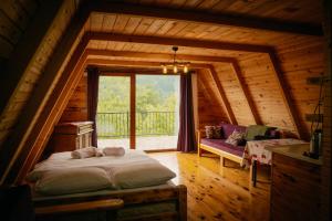 a bedroom in a log cabin with a bed and a window at Elagza Dag Evi in Rize