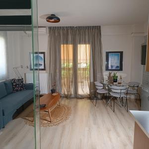 a living room with a blue couch and a table at Moris Luxury Apartments 1 in Thessaloniki