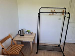 un support en fer noir à côté d'une table et d'une chaise dans l'établissement High Standard Single Room near Gatwick Airport, à Horley