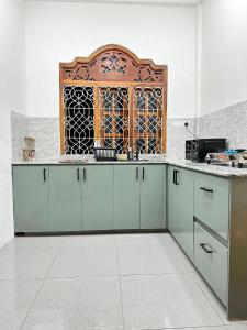 a kitchen with blue cabinets and a window at MSGuest House in Jaffna