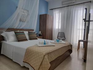 a bedroom with a bed with towels on it at House Near The Beach (Militsa & Aggeliki) in Pervolia
