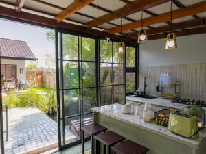 a kitchen with large windows and a large kitchen island at Karuna Villa Prambanan in Yogyakarta