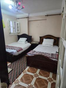 two twin beds in a room with a rug at شقة مفروشة لك وحدك قريبة من مكتبة الاسكندرية in Alexandria