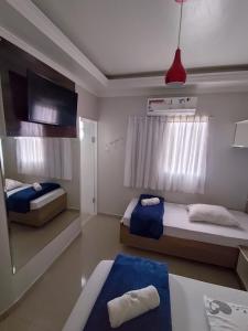 - une chambre avec 2 lits, une table et une télévision dans l'établissement M Hotel, à São Paulo