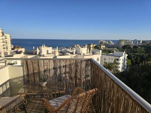a balcony with two chairs and a view of the city at Intercomercio Feja Jupiter in Benalmádena