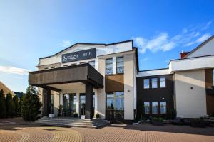 Un edificio con un cartel que dice Sussex primero en Hotel Santana, en Białystok