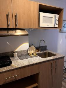 a kitchen counter with a sink and a microwave at Lay Cozy Mactan- Condo Staycation and Layovers in Pusok