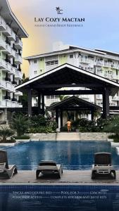 a swimming pool in front of a large building at Lay Cozy Mactan- Condo Staycation and Layovers in Pusok