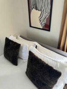 - un ensemble d'oreillers assis au-dessus d'un lit dans l'établissement Stylish countryside 4bed cottage - Kingsey, à Kingsey